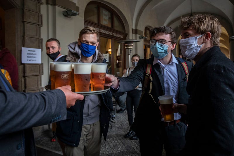 People drink beer at an outdoor seating section of a pub, as the Czech government lifted more restrictions allowing restaurants with outdoor areas to re-open
