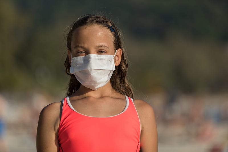 girl on beach wearing face mask