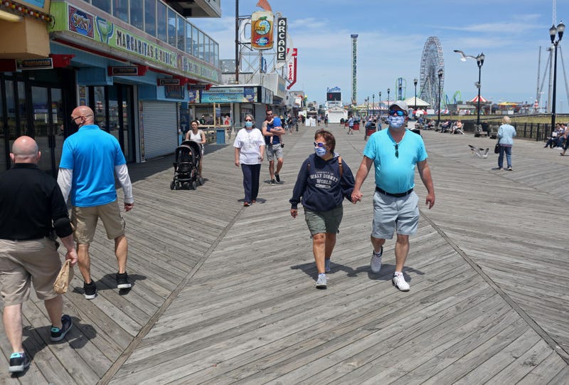People traverse the Seaside Heights boardwalk as the state begins to reopen beaches and boardwalks amid the novel coronavirus pandemic on May 16, 2020 in Seaside Heights, New Jersey.