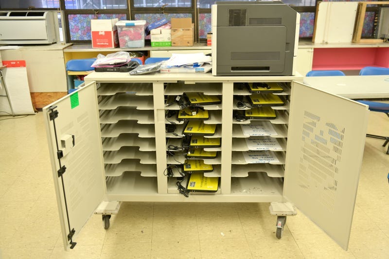 A cart is used to hold and organize school-owned laptops to be distributed to students in need for remote learning in Manhattan.