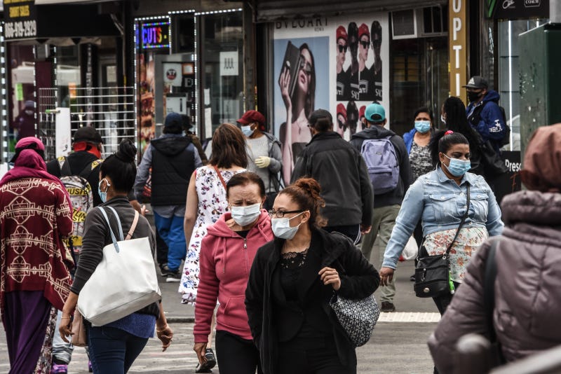 People cross the street on May 19, 2020 in the Jamaica neighborhood in the Queens borough in New York City.