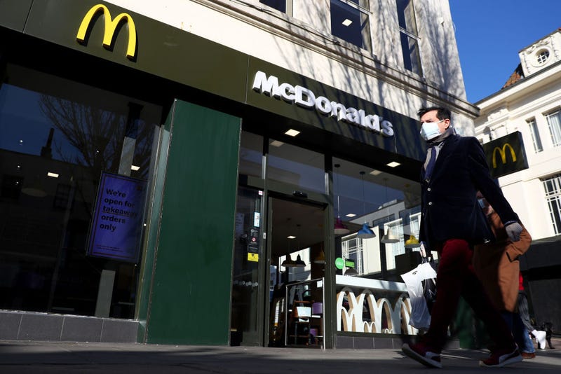 A man wearing a facemask walks past a McDonald's restaurant