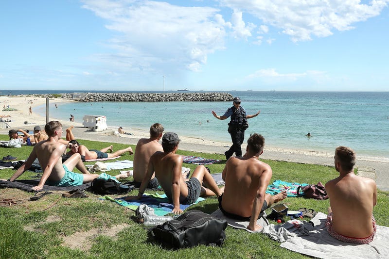Police officers encourage beach goers to keep 1.5 metres social distance on March 26, 2020 in Perth, Australia.