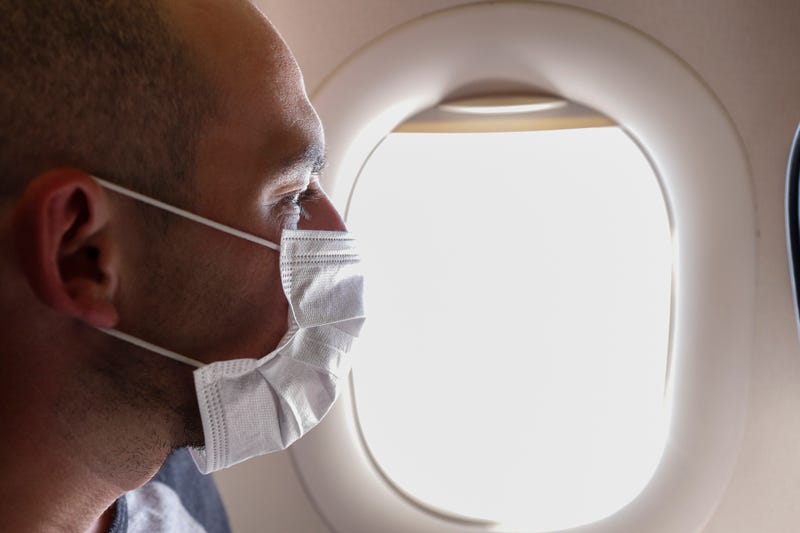 A man wearing a face mask on a flight.