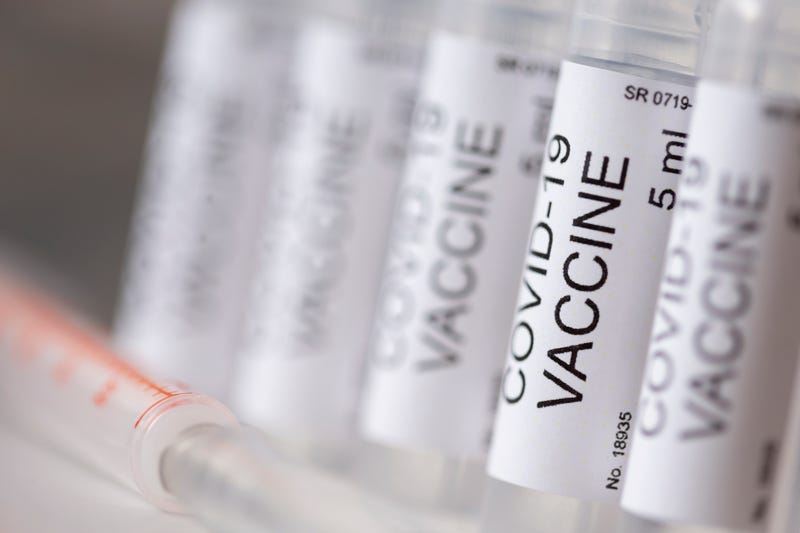 Detail of covid-19 vaccine vials and syringe; novel coronavirus treatment and prevention research concept