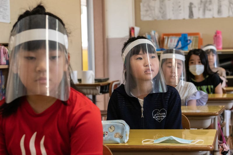 Children wearing plastic face visors sit in class at Kinugawa Elementary School on June 3, 2020 in Nikko, Japan. Schools in Japan reopened this week after being forced to close earlier in the year by the Covid-19 coronavirus outbreak. Safety measures have been implemented throughout the country, including social distancing in classrooms, use of hand sanitiser, face masks and, in some cases, plastic face visors for students and teachers.
