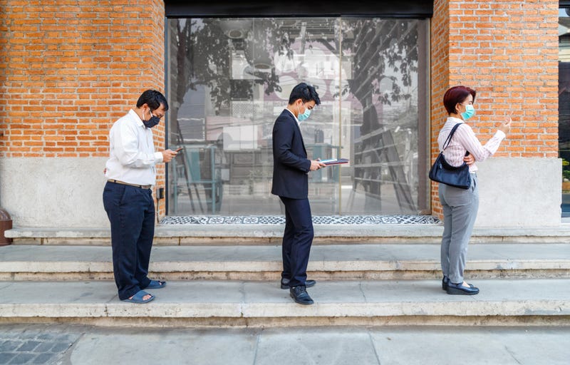 People social distance in a line