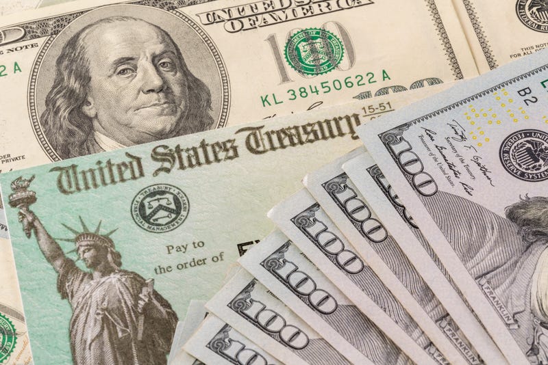Stack of 100 dollar bills with illustrative coronavirus stimulus payment check