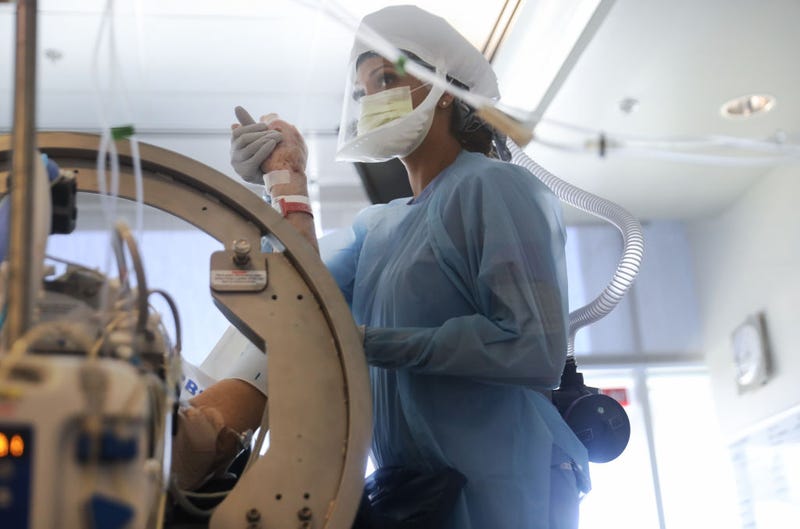 Nurse Amber Kirk wears personal protective equipment (PPE) as she performs range of motion exercises on a COVID-19 patient in the Intensive Care Unit (ICU) at Sharp Grossmont Hospital amidst the coronavirus pandemic on May 5, 2020 in La Mesa, California.