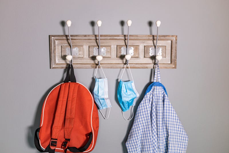 Backpack, masks and coat on hooks stock photo.