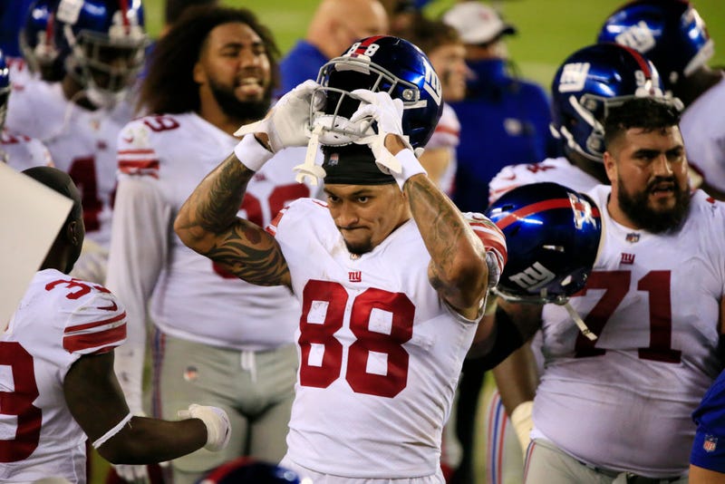 Evan Engram grimaces and removes his helmet.