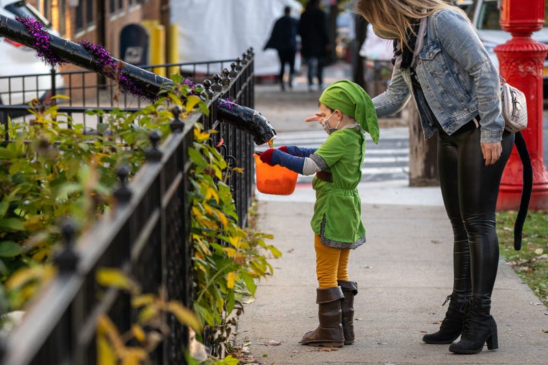 Children receive treats by candy chutes while trick-or-treating for Halloween in Woodlawn Heights on October 31, 2020 in New York City. The CDC shared on their website alternative ways to still celebrate the holiday while being safe.