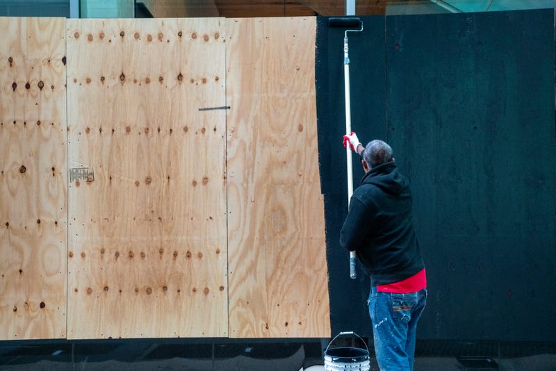 Carpenters board up and paint the windows to an American Eagle store in Times Square on November 1, 2020 in New York City.