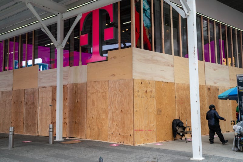 A person walks by a boarded up a T-Mobile store in Times Square on November 1, 2020 in New York City.