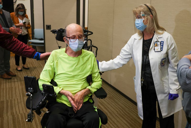 Rocky Mountain Regional VA Medical Center registered nurse Patricia Stamper, center, congratulates Army veteran Mark Maloney, 85, after he received a dose of the Pfizer-BioNTech COVID-19 vaccine at the hospital on December 16, 2020 in Aurora, Colorado. The Eastern Colorado VA Health Care System was chosen as one of 37 VA centers around the country to receive a shipment of the vaccine because of their ability to store the vaccine at extremely cold temperatures and vaccinate a large number of people.