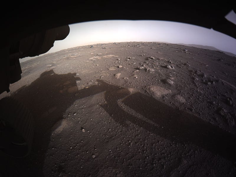 JEZERO CRATER, MARS - FEBRUARY 18: In this handout image provided by NASA, the first high-resolution, color image to be sent back by the Hazard Cameras (Hazcams) on the underside of NASA’s Perseverance Mars rover after its landing in the area known as Jezero crater on February 18, 2021 on the planet Mars. A key objective for Perseverance's mission on Mars is astrobiology, including the search for signs of ancient microbial life. The rover will characterize the planet's geology and past climate, paving the way for human exploration of the Red Planet, and be the first mission to collect and cache Martian rock and regolith