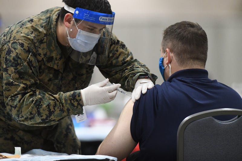 PHILADELPHIA, PA - MARCH 02: A member of the U.S. Armed Forces administers a COVID-19 vaccine to a police officer at a FEMA community vaccination center on March 2, 2021 in Philadelphia, Pennsylvania. Located at the Pennsylvania Convention Center, the site is being run as a partnership between the city and the federal government. It is part of a nearly $4 billion plan for FEMA to support more than 400 community vaccination centers across the country.