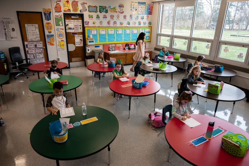 A teacher walks among the the masked students sitting in a socially distanced classroom session at Medora Elementary School on March 17, 2021 in Louisville, Kentucky.