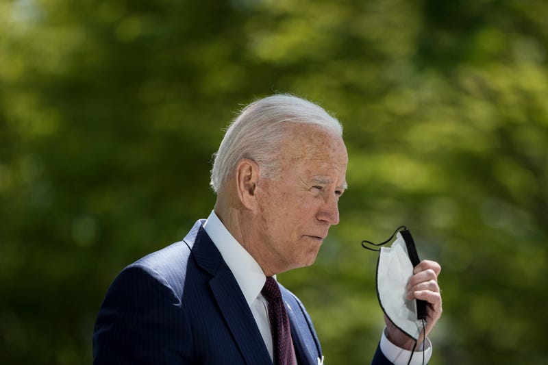 President Joe Biden removes his mask before speaking about updated CDC mask guidance in April.