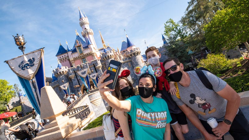 A family takes a selfie photo in front of Sleeping Beauty Castle as Disneyland Park.