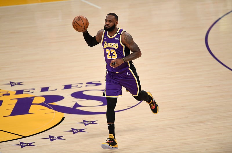 Lakers star LeBron James dribbles up the court.