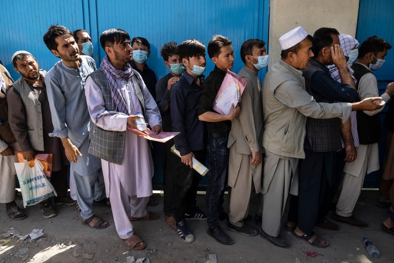 Afghans wait in long lines for hours at the passport office as many are desperate to have their travel documents ready to go on August 14, 2021 in Kabul, Afghanistan.