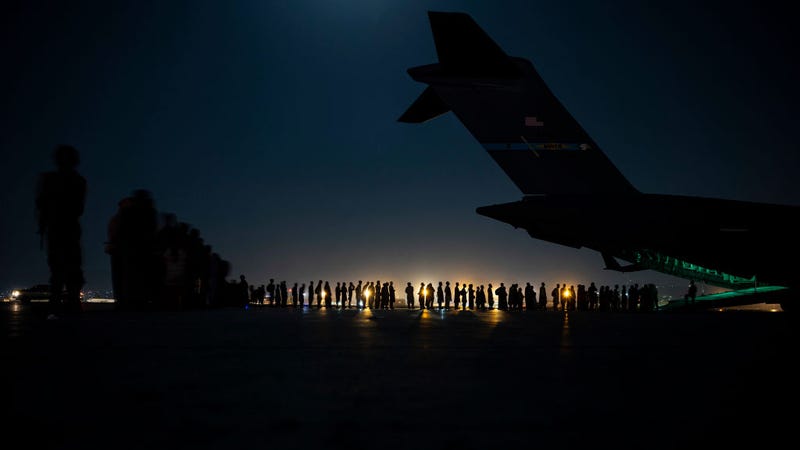 In this handout provided by the U.S. Air Force, an air crew prepares to load evacuees aboard a C-17 Globemaster III aircraft in support of the Afghanistan evacuation at Hamid Karzai International Airport on August 21, 2021 in Kabul, Afghanistan. (Photo by Taylor Crul/U.S. Air Force via Getty Images)