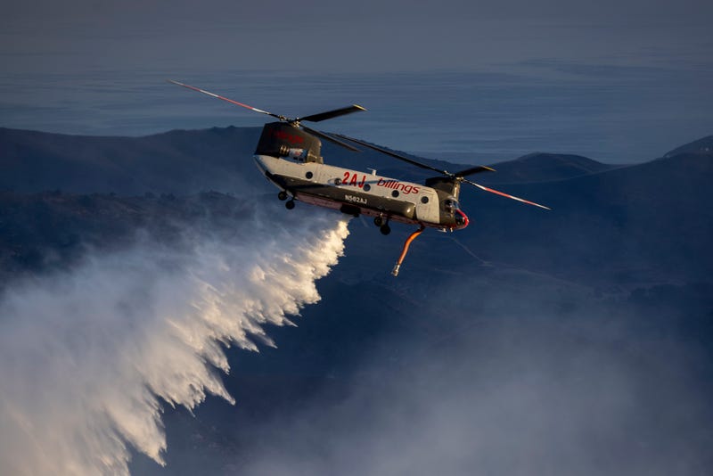 GOLETA, CA - OCTOBER 13: A firefighting helicopter makes a water drop as the Alisal Fire burns on October 13, 2021 near Goleta, California.