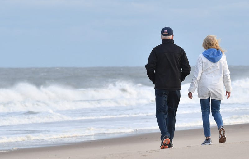 US President Joe Biden and First Lady Jill Biden walk on the beach at Cape Henlopen State Park in Lewes, Delaware on November 7, 2021.