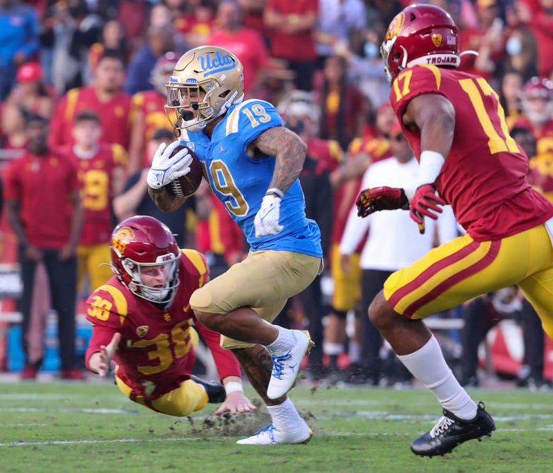 CLA running back Kazmeir Allen outruns USC kicker Alex Stadthaus, left, and linebacker Micah Croom, right, as he runs a 100-yard kickoff return for a touchdown.