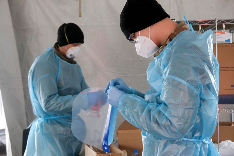 Members of the Ohio National Guard put on PPE as they prepare to administer COVID-19 tests at a drive through testing site on January 5, 2022 in Akron, Ohio.