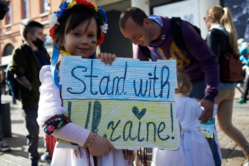 A young Ukrainian girl holds a placard as thousands march in Toulouse against the war waged by Russian President Vladimir Putin against Ukraine.