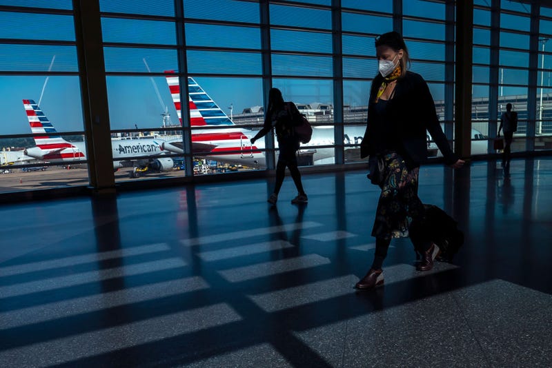 Travelers walk past American Airlines planes gated at Ronald Regan Washington National Airport on July 11, 2022 in Arlington, Virginia