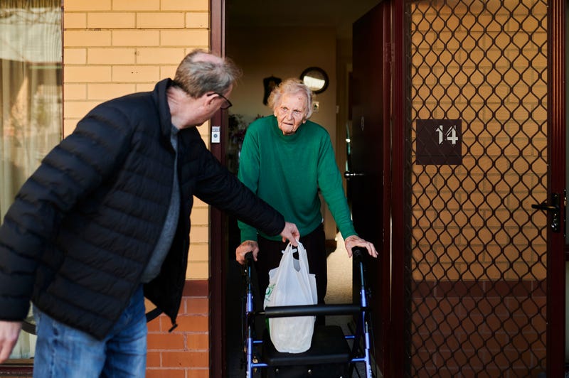 Meals on Wheels client Eleanor Lebang accepts her touch-free meal delivery on June 22, 2020, in Canberra, Australia.