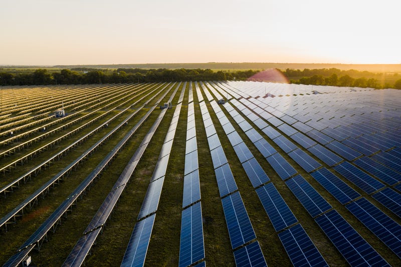 Photovoltaic modules reflect sunset light and clouds