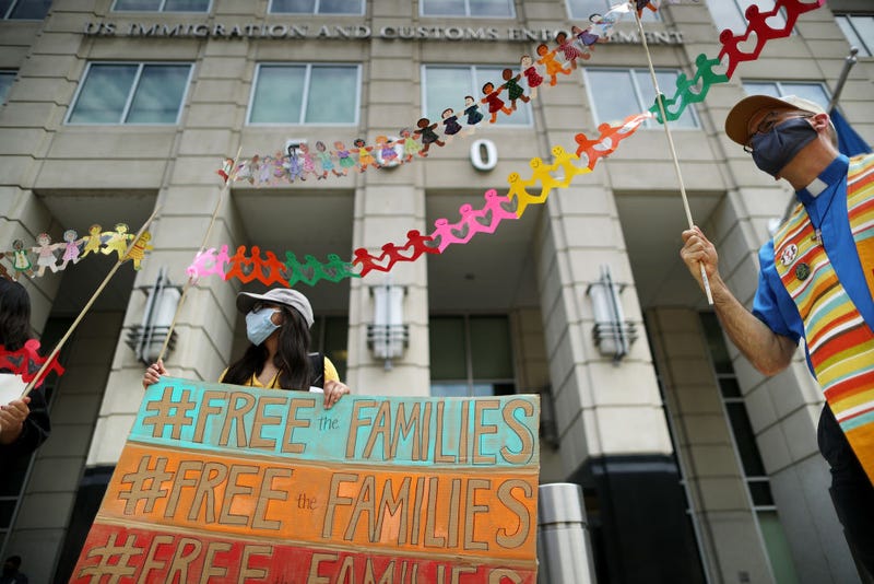 Hoisting paper dolls representing children in detention, Rev. Allen Harris (R) joins fellow protesters as they demand the release of immigrants in ICE detention due to the dangers posed by the coronavirus pandemic outside the U.S. Immigration and Customs Enforcement headquarters July 17, 2020 in Washington, DC. The demonstrators represented several organizations, including Families Belong Together, the Interfaith Immigration Coalition, the Haitian Bridge Alliance, Doctors for Camp Closure and others.