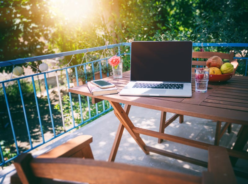 Laptop on picnic table on back porch.
