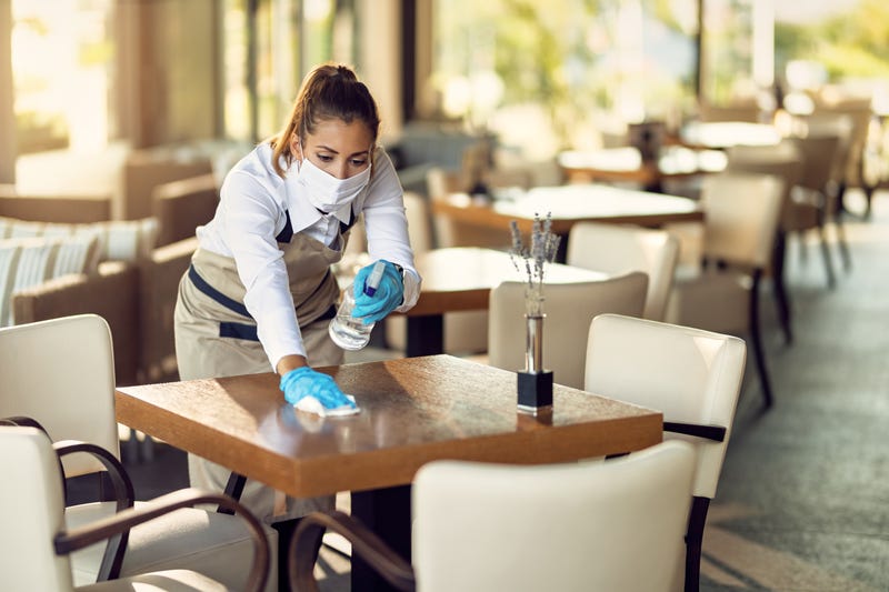 Waitress disinfecting table