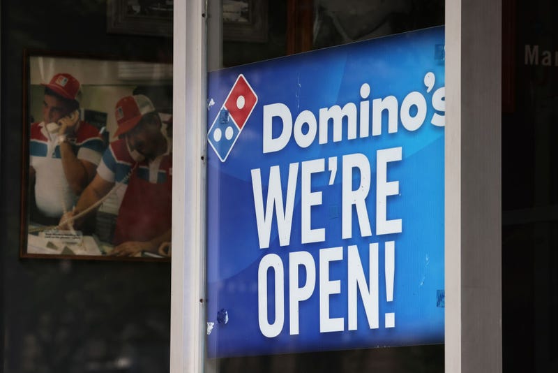 A "We're Open" sign is displayed on a window at a Domino's on August 19, 2020 in Brooklyn, New York. Domino's made an announcement on Tuesday that it is seeking to fill 20,000 positions at its corporate and franchise stores nationwide.
