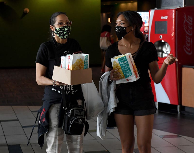 Moviegoers head into a show, mask included.