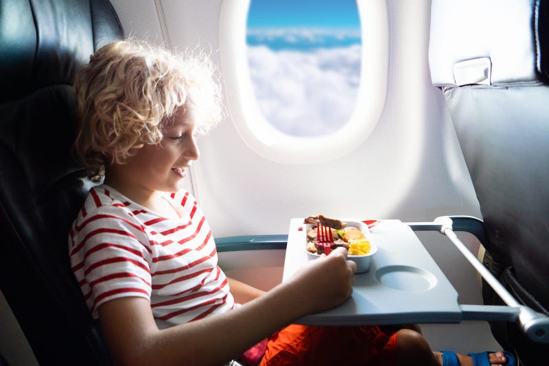 Child eating a meal on a plane.