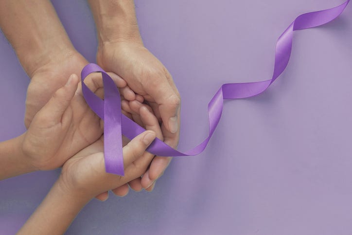 Adult and child hands holding purple ribbons for Lupus Awareness Month
