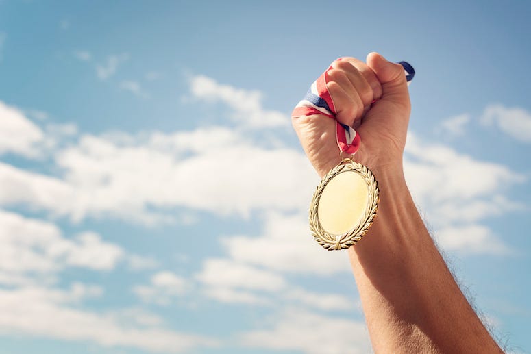 Man raising gold medal