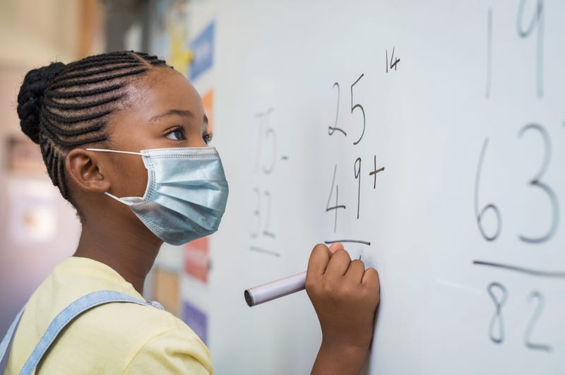 niña en la escuela usando mascarilla