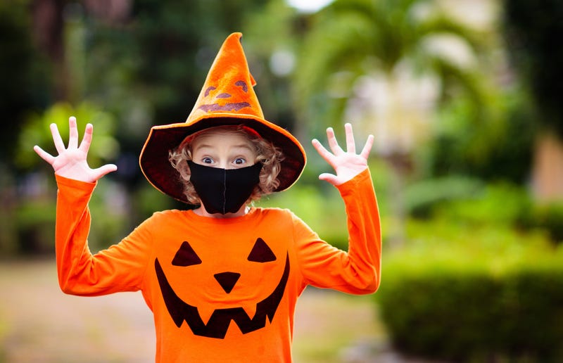 Child in Halloween costume and face mask