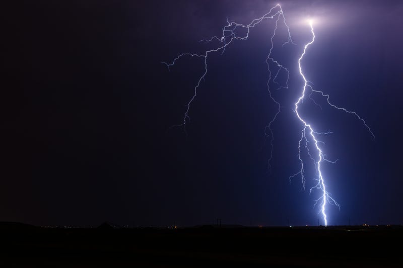 Thunderstorm lightning bolt strike from a strong storm at night.