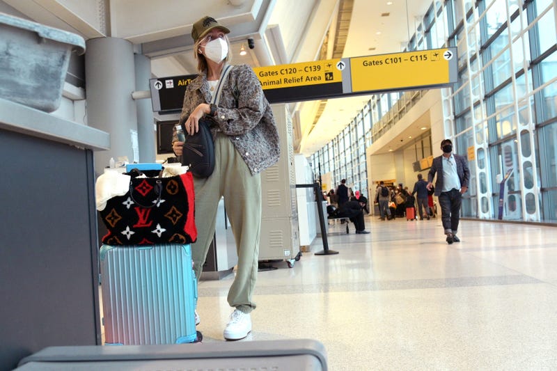 A woman gathers her belongings after passing through security at Newark Liberty International Airport on October 22, 2020 in Newark, New Jersey.