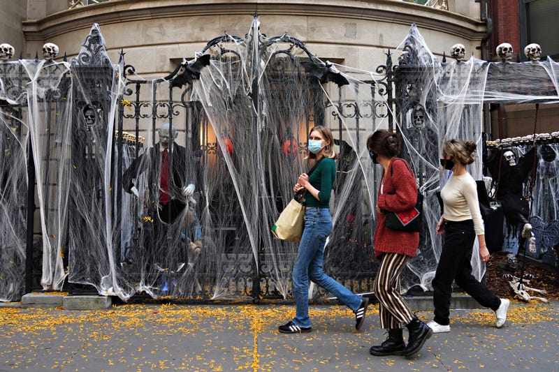 People walk by Halloween decorations outside of an Upper East Side home on October 24, 2020 in New York City.
