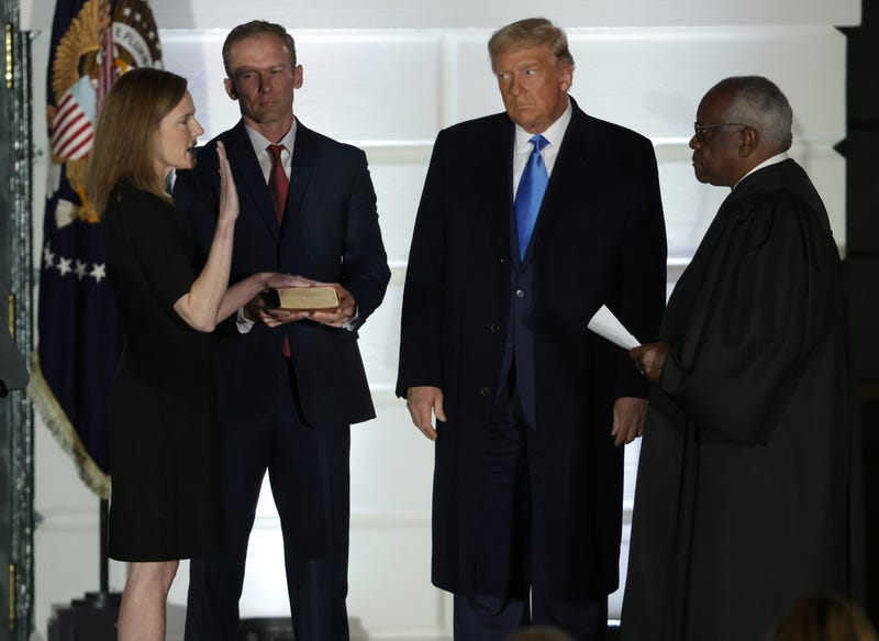 U.S. President Donald Trump (2R) watches as U.S. Supreme Court Associate Justice Amy Coney Barrett (L) is sworn in by Supreme Court Associate Justice Clarence Thomas (R) as her husband Jesse Barrett (2L) holds a bible during a ceremonial swearing-in event on the South Lawn of the White House October 26, 2020 in Washington, DC. The Senate confirmed Barrett’s nomination to the Supreme Court by a vote of 52-48.