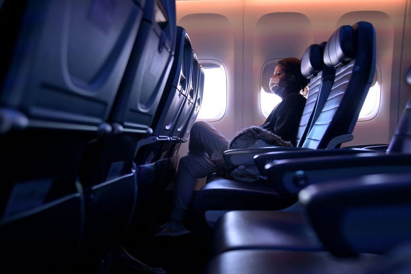 A masked passenger is seen seated on a flight from San Francisco, California to Newark, New Jersey on October 27, 2020. Although virus dissemination on flights is low when people are able to be socially distant, the extremely hard hit airline industry is having to consolidate flights, furthering complicating the dilemma. (Photo by Michael Loccisano/Getty Images)